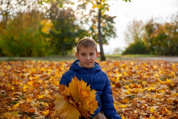 Child boy walking in the autumn park Fall leaves children concept