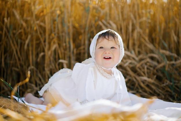 A child boy in white clothes is relaxing in the fresh air in a field