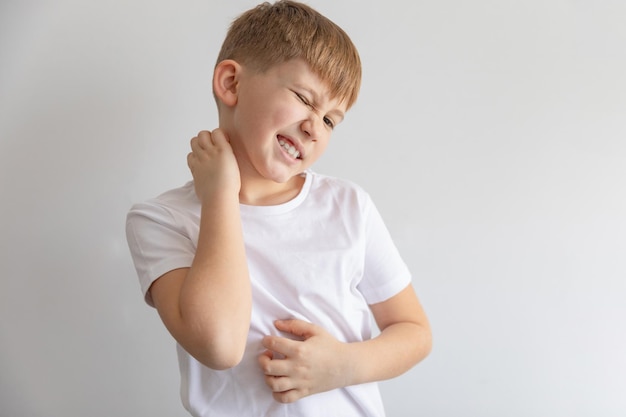 Child boy in white tshirt scratching his body Scabies skin disease rash Isolated on white background