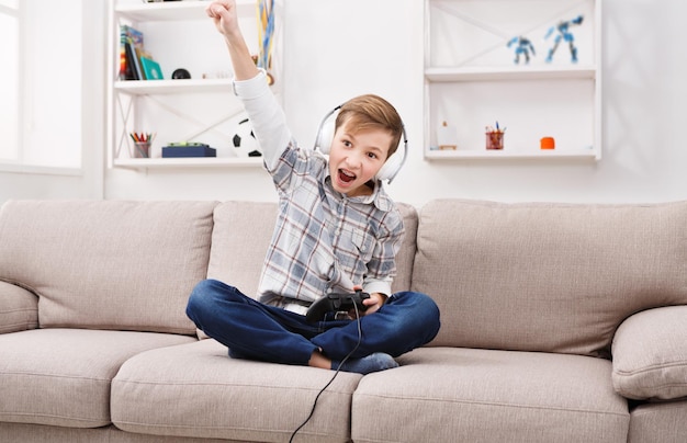 子供の男の子はビデオゲームに勝ちます。オンラインでプレイ、10代の若者向けのテクノロジーコンセプト