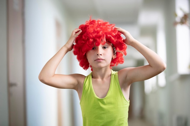 Photo a child in a bright wig funny boy with red artificial hair