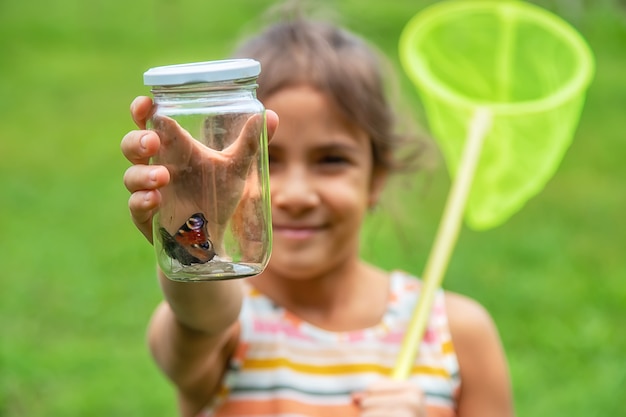 The child catches butterflies in nature. Selective focus. ,