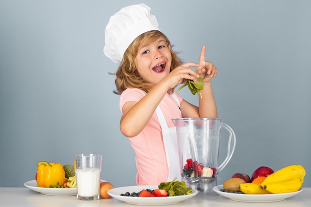 Child chef isolated on blue funny little kid chef cook wearing uniform cook cap and apron cooked foo
