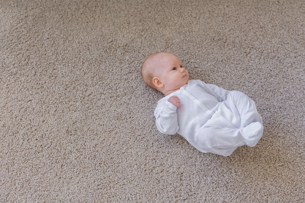 Child, childhood and infant concept - Pretty baby lie on the floor.