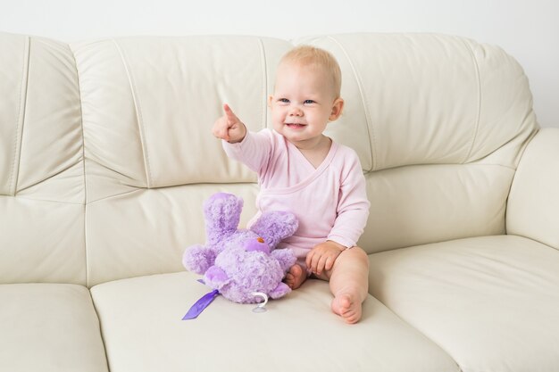 Child, childhood and kids concept - beautiful smiling baby sitting.