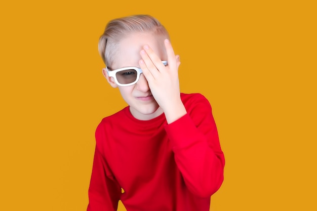 A child in children's 3D glasses covered his eyes with his hand
