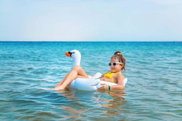 child in a circle swims in the sea. 