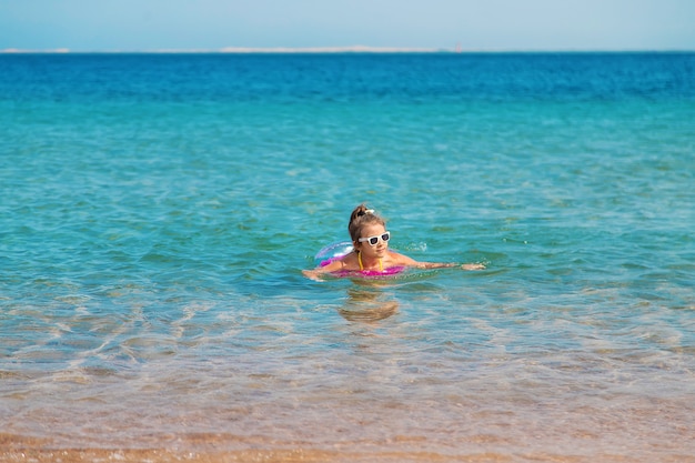 child in a circle swims in the sea. 