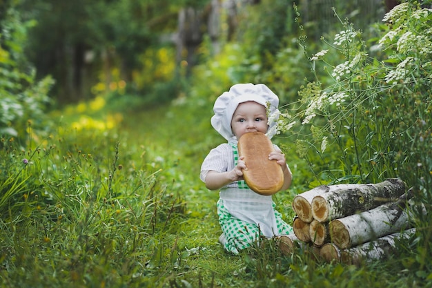 The child in the clothes of a Baker eats the loaf 4691