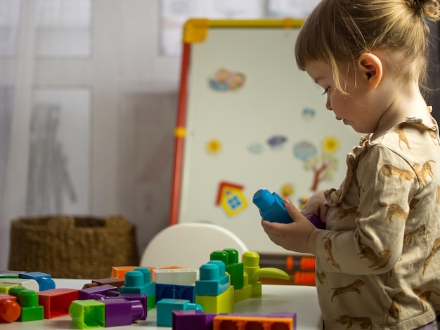 The child collects the designer at the table in the children's room