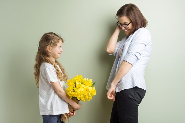 子供は母親を祝福し、彼女の花束を与えます