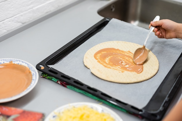 Foto il bambino cucina la pizza fatta in casa, la bambina fa la pizza a casa