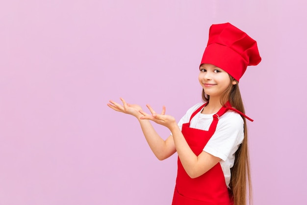 The child in the cook's costume stretched out her hands to the side and smiles children like to cook food themselves baby food