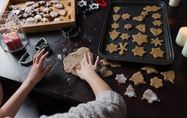 A child cooks Christmas cookies at the table top view