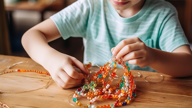 子供が珠でネックレスを作っています 色と創造性で作っています