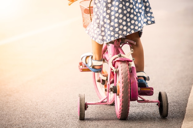 Foto bambina carina bambina che guida bici nel parco