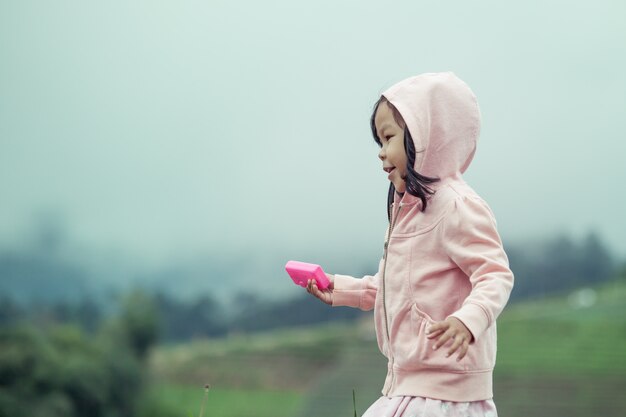 雨の後、庭で走っている子供のかわいい女の子