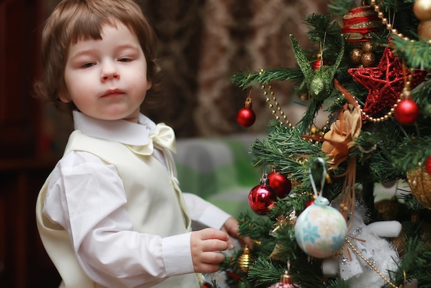 子供はクリスマスツリーのおもちゃを飾る