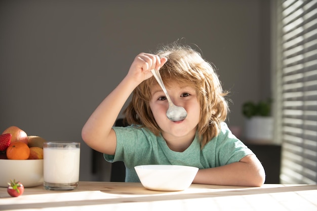 Child dinner portrait of fun kid having healthy tasty snack small kid crazy posing by kitchen table