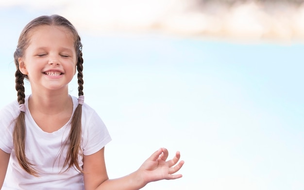 Photo child doing exercise on platform outdoors. healthy ocean lifestyle. yoga girl