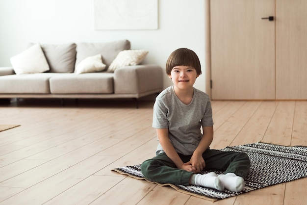 自宅の床に座っている子供ダウン症