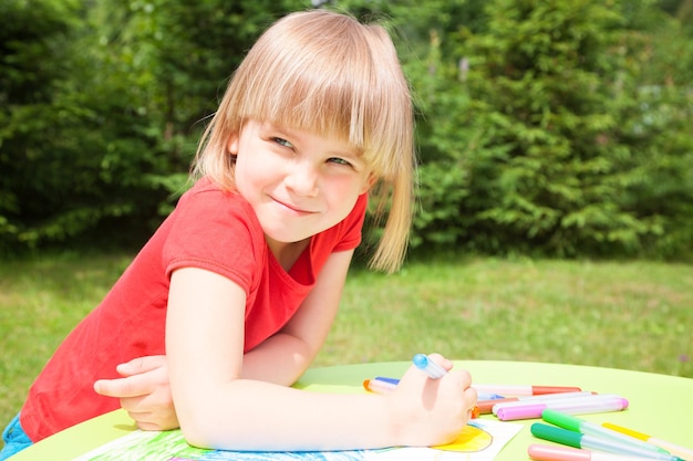 Child drawing in a summer garden