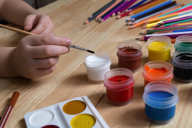 Foto il bambino disegna e molte matite e colori per disegnare