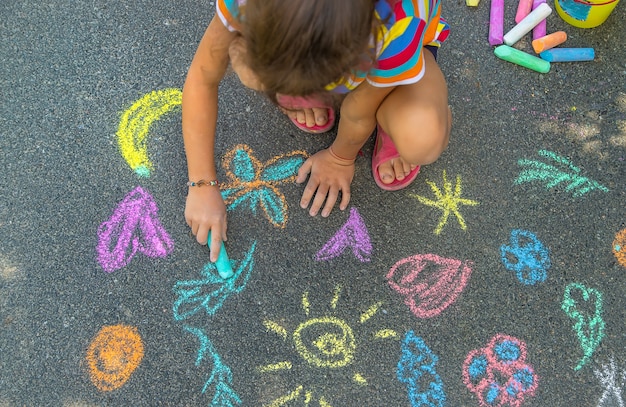 子供はアスファルトにチョークで描く