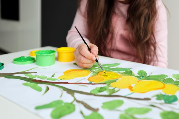 The child draws with paints the concept of a children's lesson