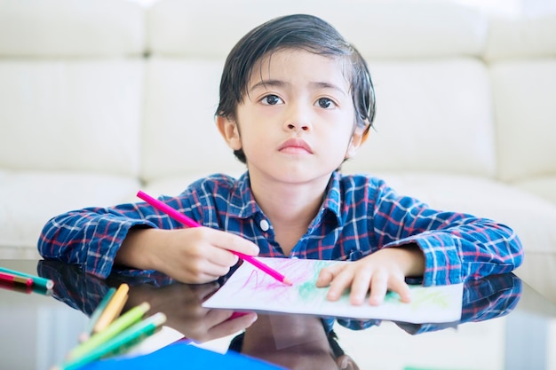 Child draws with pencil during quarantine at home