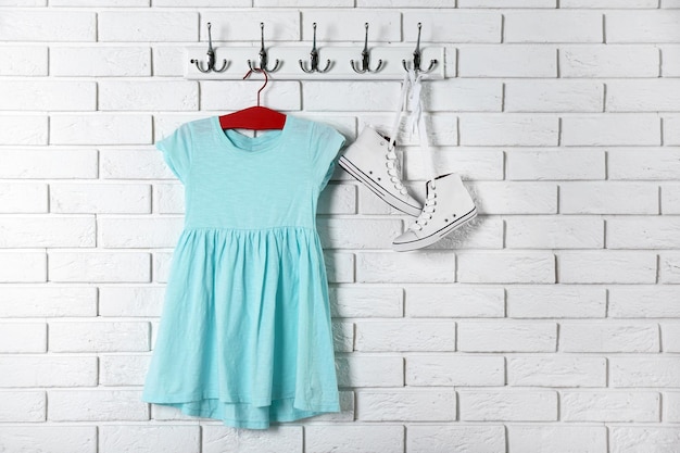 Photo child dress on hanger on white wall background