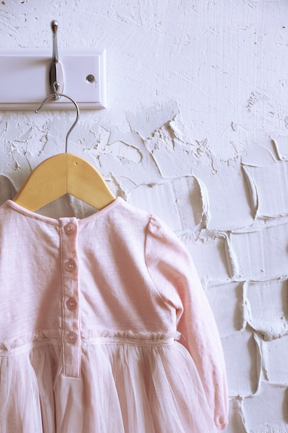 Child dress on hanger on white wall