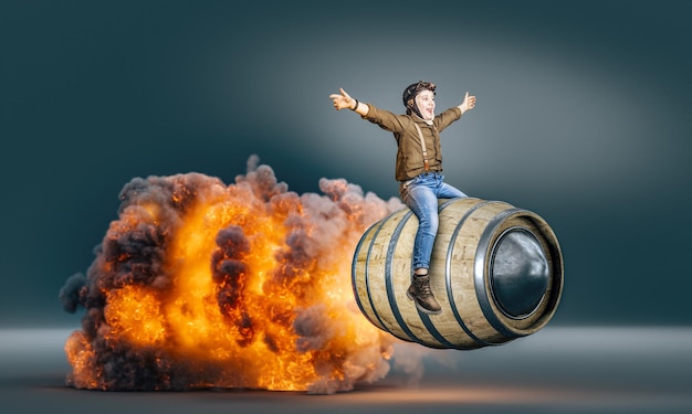 Child dressed as an aviator on a flying barrel