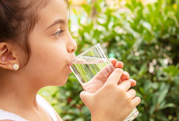 自然の中で純粋な水を飲む子供。selectivfokus.nature