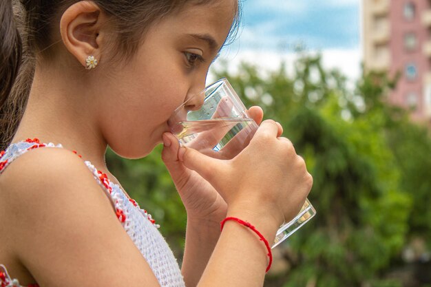 自然の中で純粋な水を飲む子供。selectivfokus