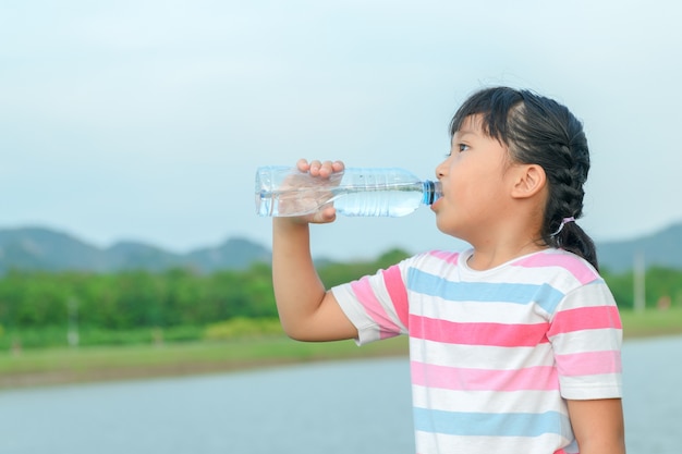 Child drinking pure water in nature