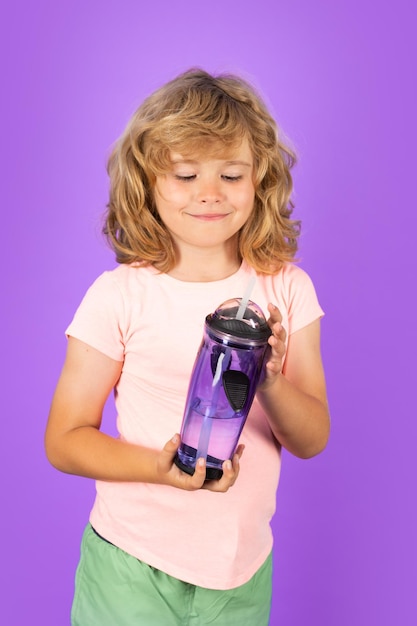 Child drinking water isolated on studio background kid enjoy pure fresh mineral water thirsty kid