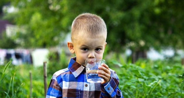 The child drinks clean water in nature.