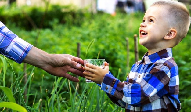 The child drinks clean water in nature.