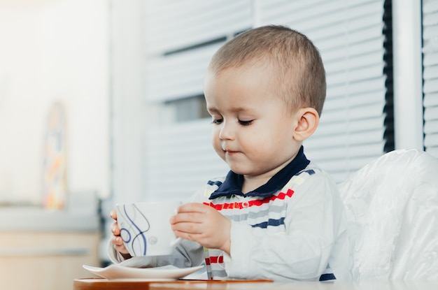 子供がお茶、コーヒー、ココア、家庭の台所を飲む