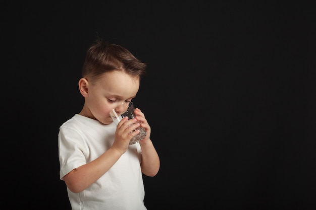 A child drinks water on a black