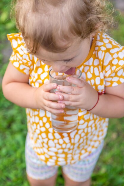The child drinks water from a glass Selective focus
