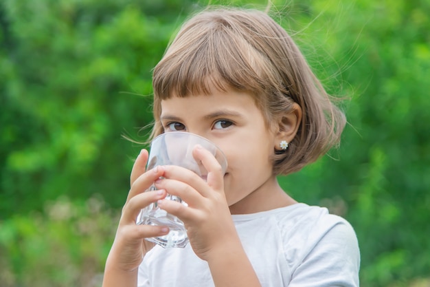 Photo child drinks water from a glass