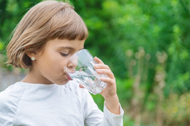 子供はグラスから水を飲む