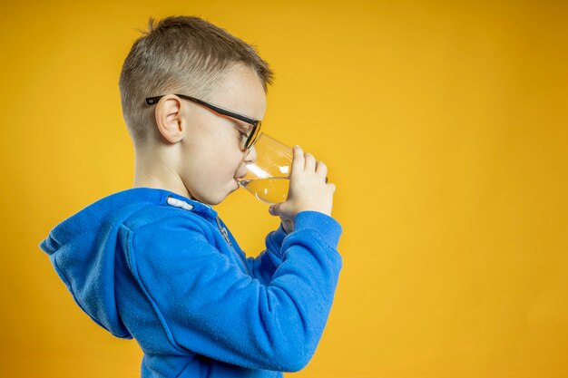 A child drinks water on a turquoise wall