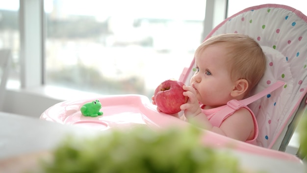 リンゴを食べる子供 赤ちゃんの健康食品のコンセプト 果物を食べる甘い赤ちゃん