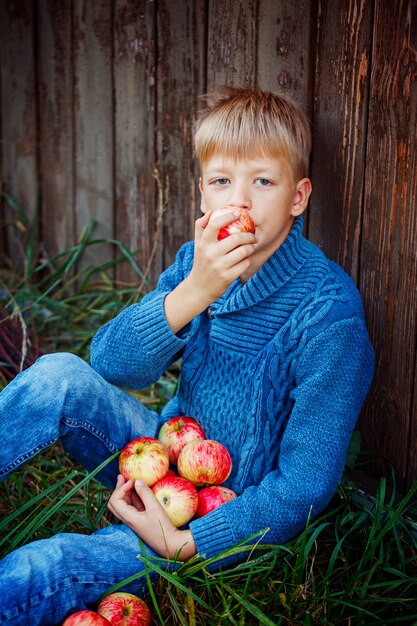 Child eating an apple outside in the garden