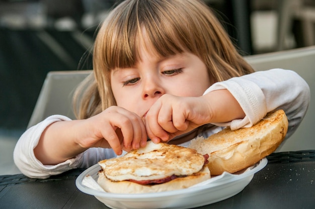 子供が朝食のサンドイッチを食べている