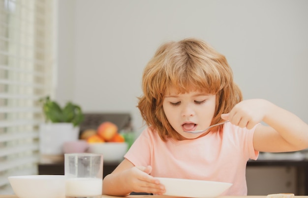 Child eating healthy food at home baby eat soup with spoon