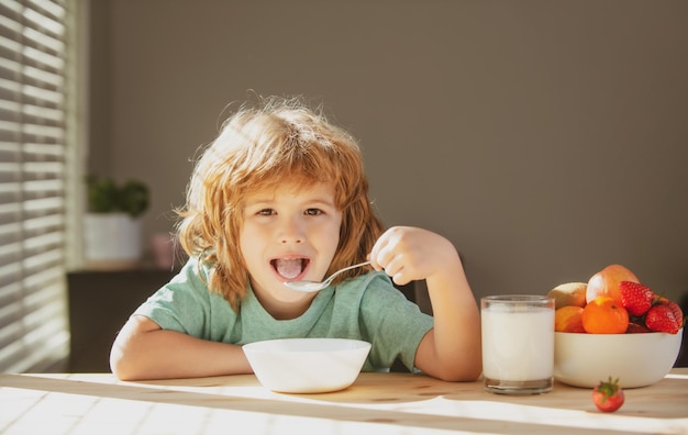 Child eating healthy food at home baby eat soup with spoon